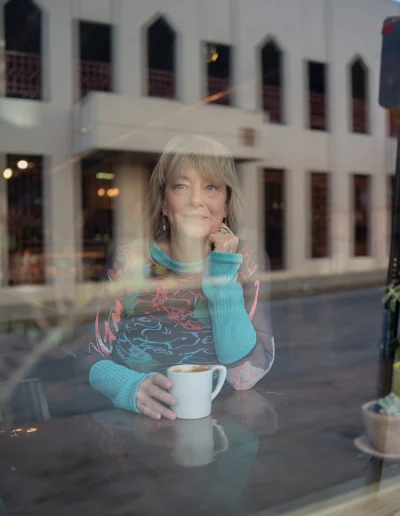 Brenda looking through a window downtown Asheville getting a portrait taken