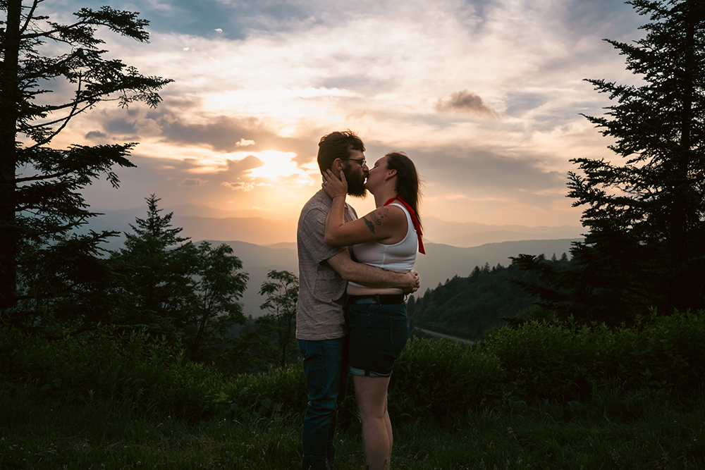 Couple kissing during sunset on the blue ridge parkway during a couples photoshoot in Asheville